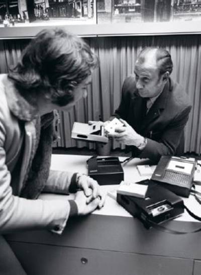 Im Historischen Museum Hannover werden Tonbandführungen angeboten. Ein Mann erläutert einem anderen die Handhabung eines Kassettenspielers. Foto von Wilhelm Hauschild, 1973.