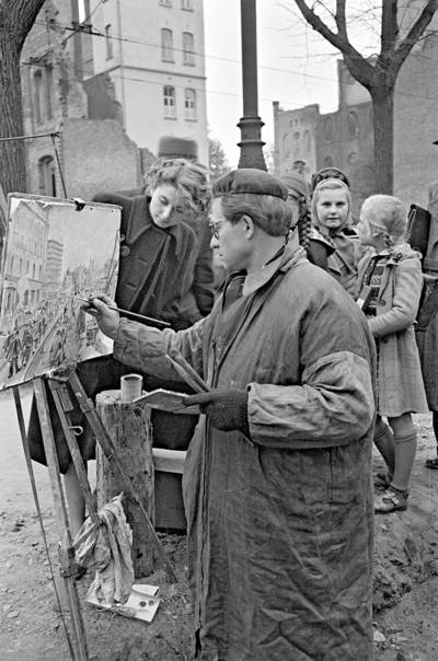 Maler Hans Kreuzer bei der Arbeit auf der Straße in Hannover, Foto von Wilhelm Hauschild, 11.1950