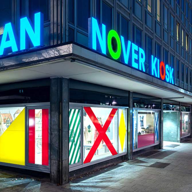 Beleuchtete Front vom Hannover Kiosk bei Nacht mit Blick in die Karmarschstraße