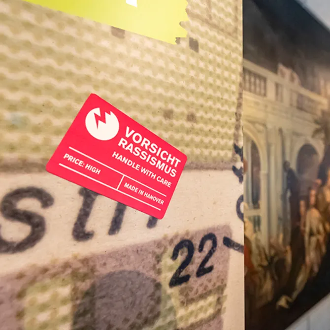 Blick in die Sonderausstellung "Von goldenen Kutschen und kolonialer Vergangenheit: Hannover, England und die Sklaverei", vom 12. Juli bis 13. November 2022 im HMH, hier der rechteckige rote Sticker "Vorsicht Rassismus"