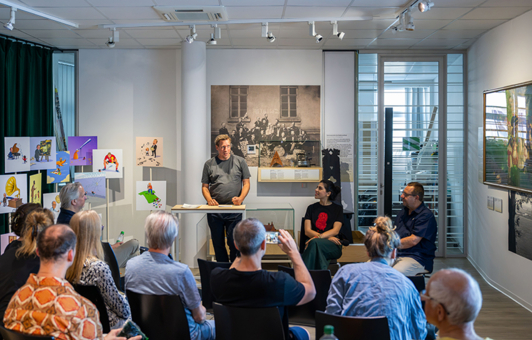 Künstlerinnengespräch, am Pult Dr. Jan Willem Huntebrinker,  sitzend Farzane Vaziritabar und Dr. Reinhard Spieler, Leiter des Sprengelmuseums, im Vordergrund Gäste