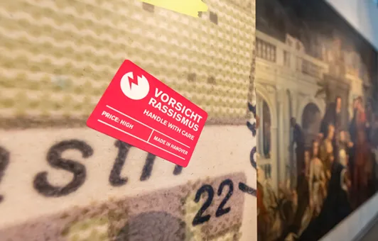 Blick in die Sonderausstellung "Von goldenen Kutschen und kolonialer Vergangenheit: Hannover, England und die Sklaverei", vom 12. Juli bis 13. November 2022 im HMH, hier der rechteckige rote Sticker "Vorsicht Rassismus"