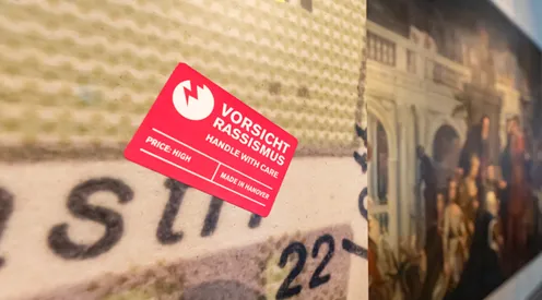 Blick in die Sonderausstellung "Von goldenen Kutschen und kolonialer Vergangenheit: Hannover, England und die Sklaverei", vom 12. Juli bis 13. November 2022 im HMH, hier der rechteckige rote Sticker "Vorsicht Rassismus"